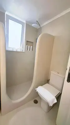 a bathroom with a shower with a toilet and a window at Pallas in Keratea