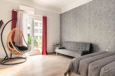a bedroom with a bed and a couch and a window at Apt w/ View of OlympusZeusTemple/4BEDR-3BATH-2KITC in Athens