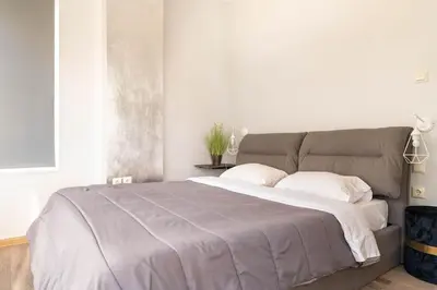 a bedroom with a large bed with two pillows at Apt w/ View of OlympusZeusTemple/4BEDR-3BATH-2KITC in Athens