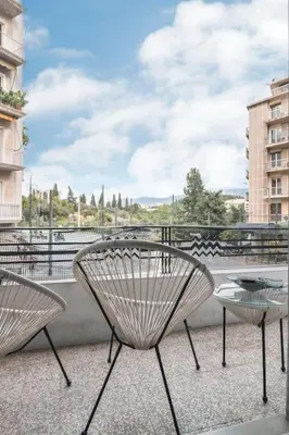 two chairs and a table on a balcony at Apt w/ View of OlympusZeusTemple/4BEDR-3BATH-2KITC in Athens