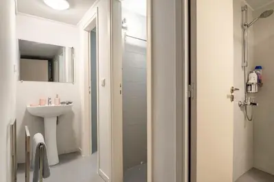 a white bathroom with a sink and a shower at Apt w/ View of OlympusZeusTemple/4BEDR-3BATH-2KITC in Athens