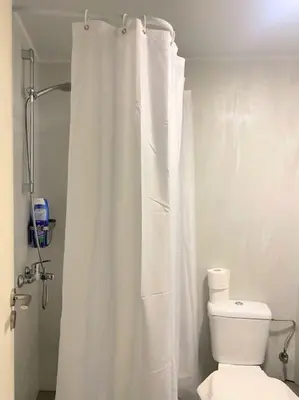 a bathroom with a white shower curtain and a toilet at Apt w/ View of OlympusZeusTemple/4BEDR-3BATH-2KITC in Athens