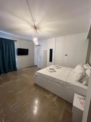 a bedroom with a large white bed and a television at Nikis Penthouse in Athens