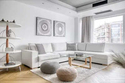 a living room with a white couch and a table at Kallirrois 89 Suite in Athens