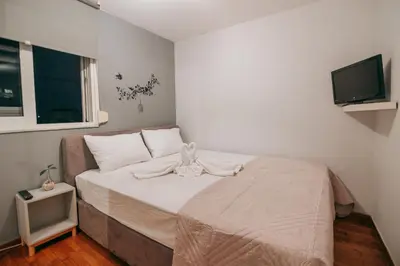 a small bedroom with a bed and a flat screen tv at Acropoli's balcony in Athens