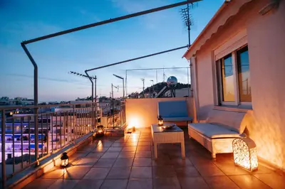 a balcony with a couch and a table on a building at Acropoli's balcony in Athens