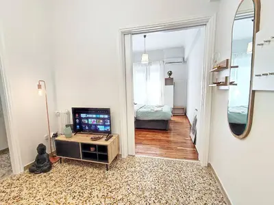 a living room with a television and a bedroom at As ✓Two bedroom apartment in thissio in Athens