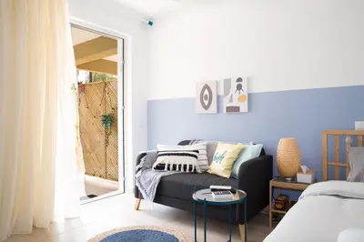 a living room with a couch and a window at Boho Blu by A&D Properties in Porto Rafti