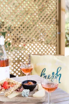 a table with two glasses of wine and a plate of food at Boho Blu by A&D Properties in Porto Rafti