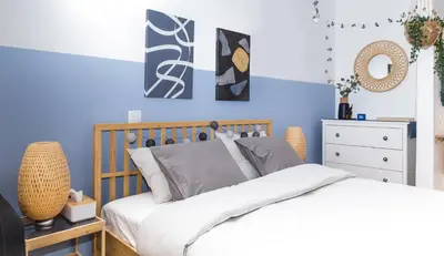 a bedroom with blue walls and a bed and a dresser at Boho Blu by A&D Properties in Porto Rafti