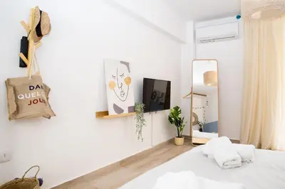 a white bedroom with a bed and a mirror at Boho Blu by A&D Properties in Porto Rafti