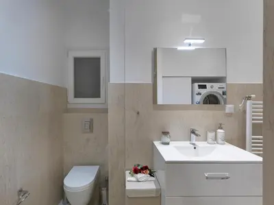 a bathroom with a sink and a toilet and a mirror at Newly Renovated Apartment in the Heart of Athens in Athens