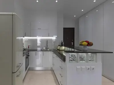 a white kitchen with a bowl of fruit on the counter at Newly Renovated Apartment in the Heart of Athens in Athens