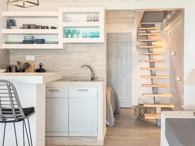 a staircase in a kitchen with white cabinets at Pallas Seaside 1 in Athens