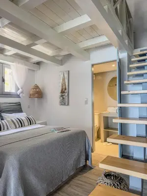 a bedroom with a bed and a spiral staircase at Pallas Seaside 1 in Athens