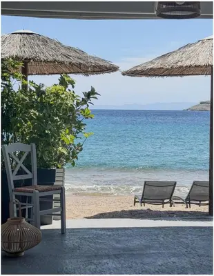 two chairs and umbrellas on a beach with the ocean at Pallas Seaside 1 in Athens