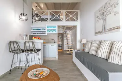 a living room and kitchen with a couch and a table at Pallas Seaside 1 in Athens