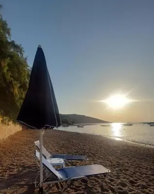 a beach chair and an umbrella on a beach at Pallas Seaside 1 in Athens
