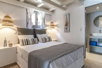 a white bedroom with a large bed and a sink at Pallas Seaside 1 in Athens
