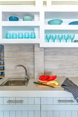 a kitchen with blue and white cabinets and a sink at Pallas Seaside 2 in Athens