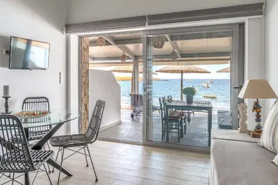 a living room with a table and chairs and a view of the ocean at Pallas Seaside 2 in Athens