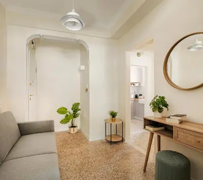 a living room with a couch and a mirror at HoneyBee Apartment in Athens