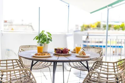 a table with plates of food on a balcony at HoneyBee Apartment in Athens