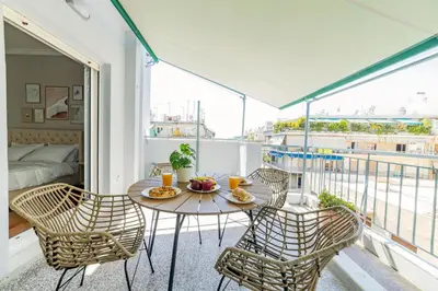 a balcony with a table and chairs and a bed at HoneyBee Apartment in Athens