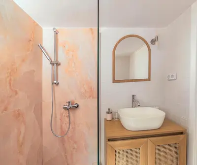 a bathroom with a shower with a sink and a mirror at HoneyBee Apartment in Athens