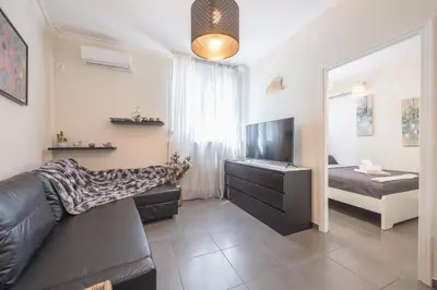 a living room with a couch and a television at Drakou Studio in Athens