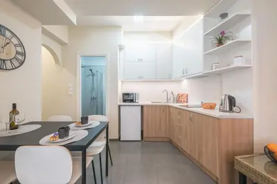 a kitchen with white cabinets and a black counter top at Drakou Studio in Athens