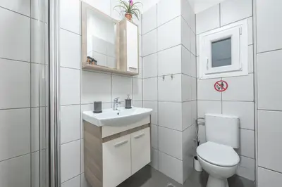 a white bathroom with a toilet and a sink at Drakou Studio in Athens