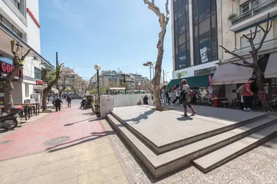 a person walking down a sidewalk in a city at Drakou Studio in Athens