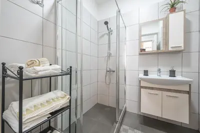 a white bathroom with a shower and a sink at Drakou Studio in Athens