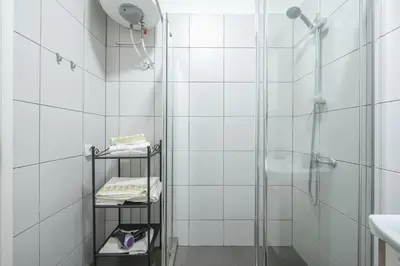 a bathroom with a shower with white tiles at Drakou Studio in Athens