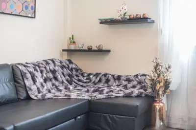 a blanket on a couch in a living room at Drakou Studio in Athens