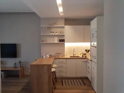 a kitchen with white cabinets and a wooden island at Elegant House With Acropolis View in Athens