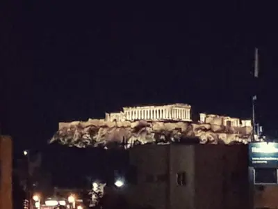 a building on top of a hill at night at Elegant House With Acropolis View in Athens
