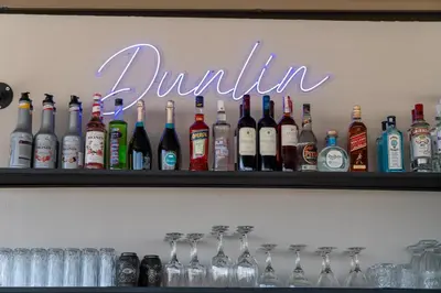 a shelf filled with lots of bottles of alcohol at Dunlin Hotel in Athens