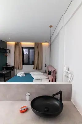 a bathroom with a black bath tub next to a bed at Dunlin Hotel in Athens