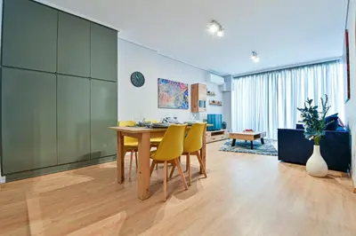 a dining room with a table and yellow chairs at Beautiful new apartment 5 min from Piraeus Port (A2) in Piraeus