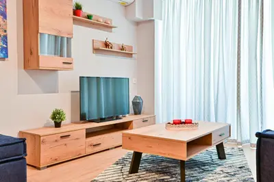 a living room with a tv and a coffee table at Beautiful new apartment 5 min from Piraeus Port (A2) in Piraeus