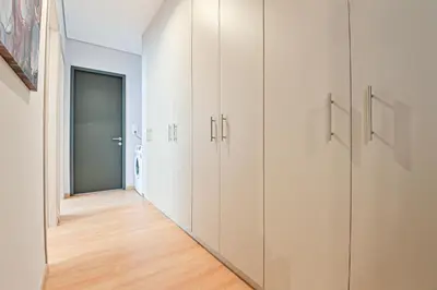 a row of white cabinets in a hallway at Beautiful new apartment 5 min from Piraeus Port (A2) in Piraeus