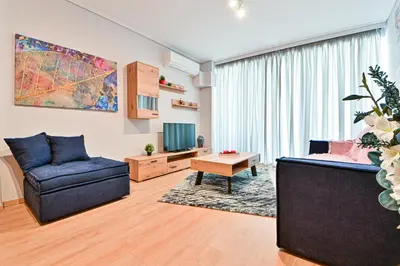 a living room with a couch and a tv at Beautiful new apartment 5 min from Piraeus Port (A2) in Piraeus