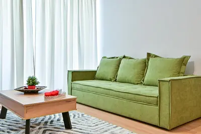 a living room with a green couch and a coffee table at Waylink Residences - Piraeus Port SPT in Piraeus