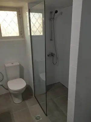 a bathroom with a toilet and a glass shower stall at Cozy Loft with Jazz Notes in Kolonaki in Athens