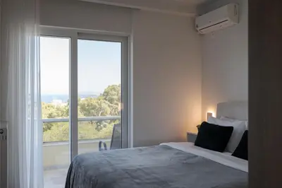 a bedroom with a bed and a large window at Athenian Riviera Sea View Penthouse in Vari