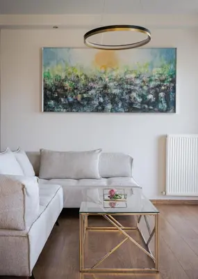 a living room with a couch and a painting on the wall at Athenian Riviera Sea View Penthouse in Vari