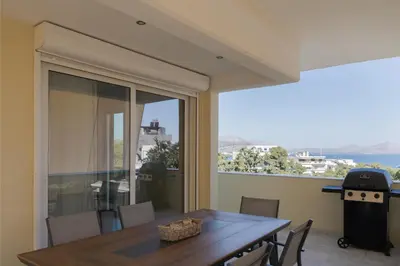 a dining room with a table and a balcony at Athenian Riviera Sea View Penthouse in Vari