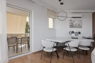 a dining room with a white table and chairs at Athenian Riviera Sea View Penthouse in Vari